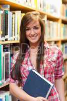 Portrait of a smiling female student holding a book