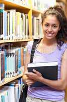 Portrait of a smiling female student posing with a book
