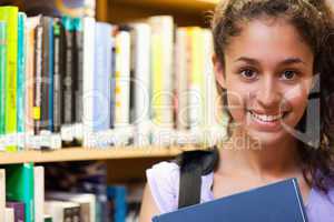 Happy female student holding a book