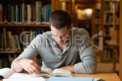 Male student researching with a book