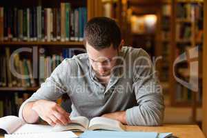 Male student researching with a book