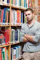 Portrait of a male student leaning on a shelf