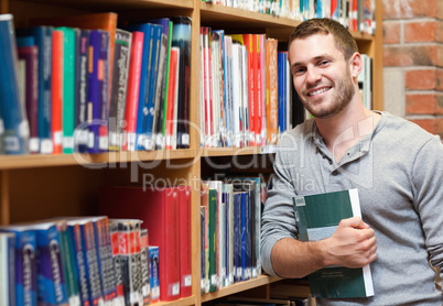 Smiling male student holding a book