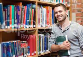 Smiling male student holding a book