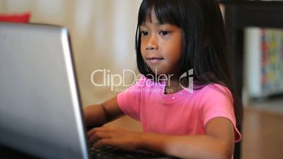 Little Girl Playing Games On A Lap Top Computer