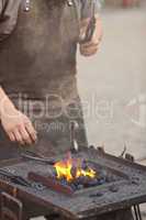 embers, fire, smoke, tools and the hands of a blacksmith