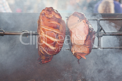 huge chunks of pork roasting on a spit