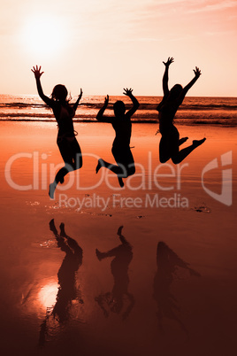 Three people silhouettes jumping on the beach