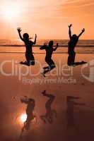 Three people silhouettes jumping on the beach