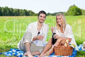 Picnic young happy couple celebrating with wine