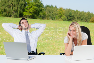 Business colleagues in nature with laptop relax