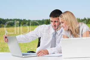 Business colleagues in sunny nature with laptop