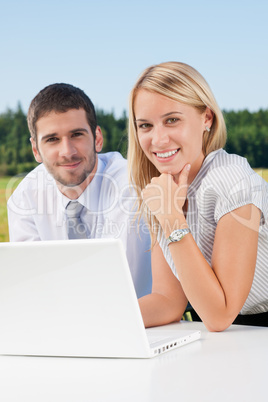 Business colleagues in nature with laptop smile