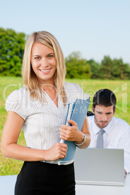 Businesswoman in sunny nature with folders smile