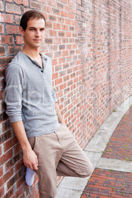 Portrait of a student leaning on a wall