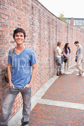 Portrait of a student posing while his friends are talking