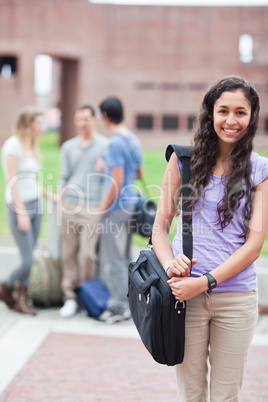 Portrait of a smiling student posing while his classmates are ta