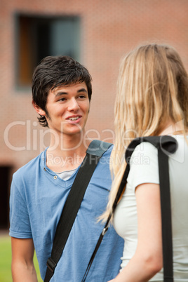 Portrait of a surprised student talking with a friend