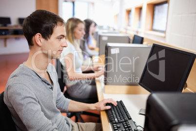 Serious male student working with a computer