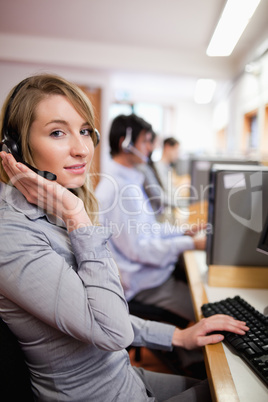 Portrait of a smiling blonde operator posing with a headset