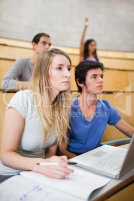 Portrait of students listening a lecturer while their classmate