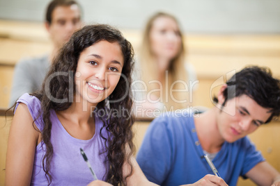 Smiling student taking notes