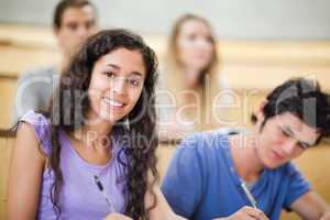 Smiling student taking notes
