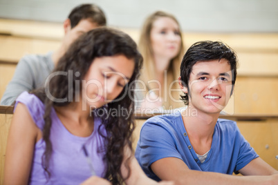 Student being distracted while his classmates are listening