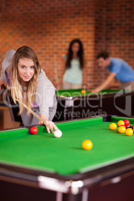 Portrait of a student woman playing snooker