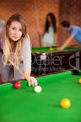 Portrait of a young woman playing snooker