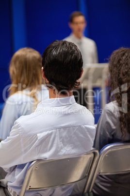 Portrait of young people listening to a man