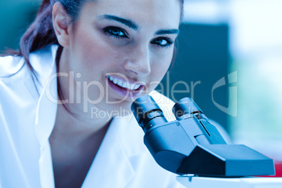Young scientist posing with a microscope