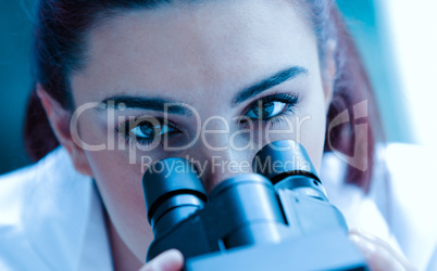 Close up of a scientist posing with a microscope