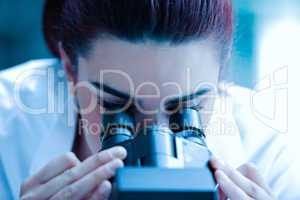 Young scientist looking through a microscope