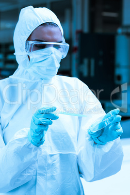 Protected scientist dropping dangerous liquid in a Petri dish