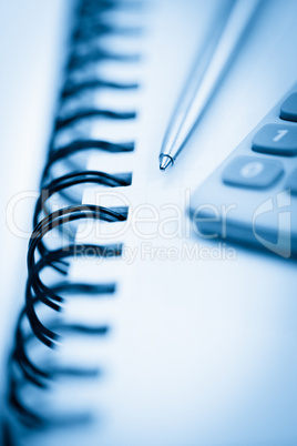 Spiral notebook with pencil and pocket calculator
