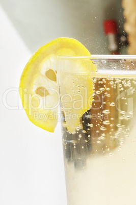 Glass goblet with sparkling lemonade and lemon