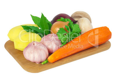 Board with potatoes, garlic, carrots, mushrooms