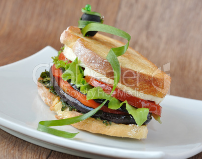 Sandwich with eggplant, tomatoes, peppers and cheese