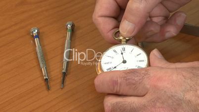 Watchmaker examines pocket watch