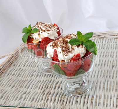 Strawberries with biscuit pieces with mint whipped cream under