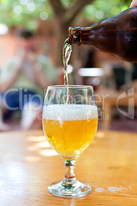 Bottle of beer flowing into the glass