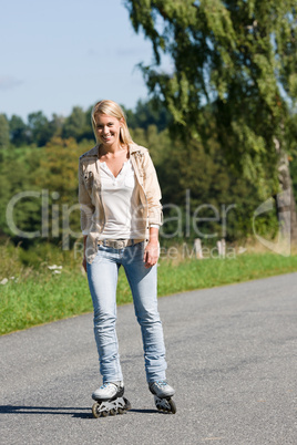 Inline skating young woman on sunny asphalt road