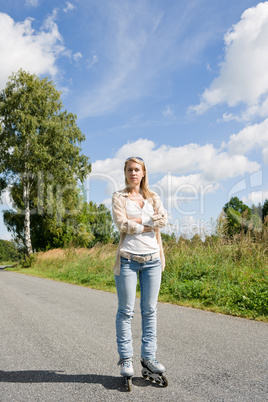 Inline skating young woman on sunny asphalt road