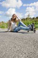 Inline skates young woman sitting asphalt road