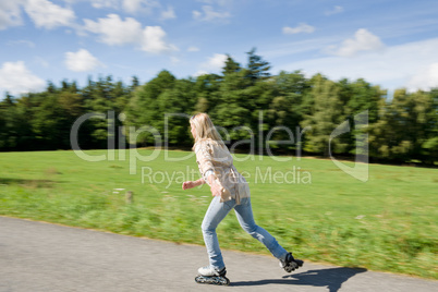 Inline skating young woman speed workout sunny