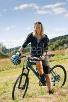 Mountain biking young woman sportive sunny meadows