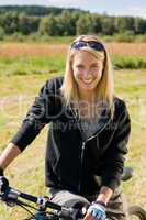 Mountain biking young woman sportive sunny meadows