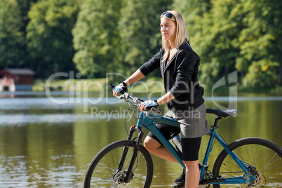 Mountain biking young woman standing by lake