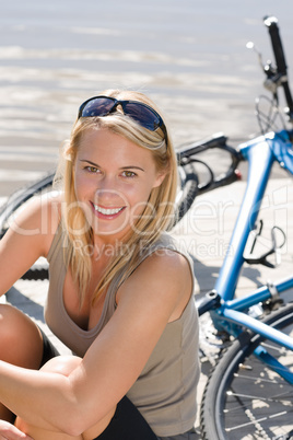 Sport biking young woman sitting by lake